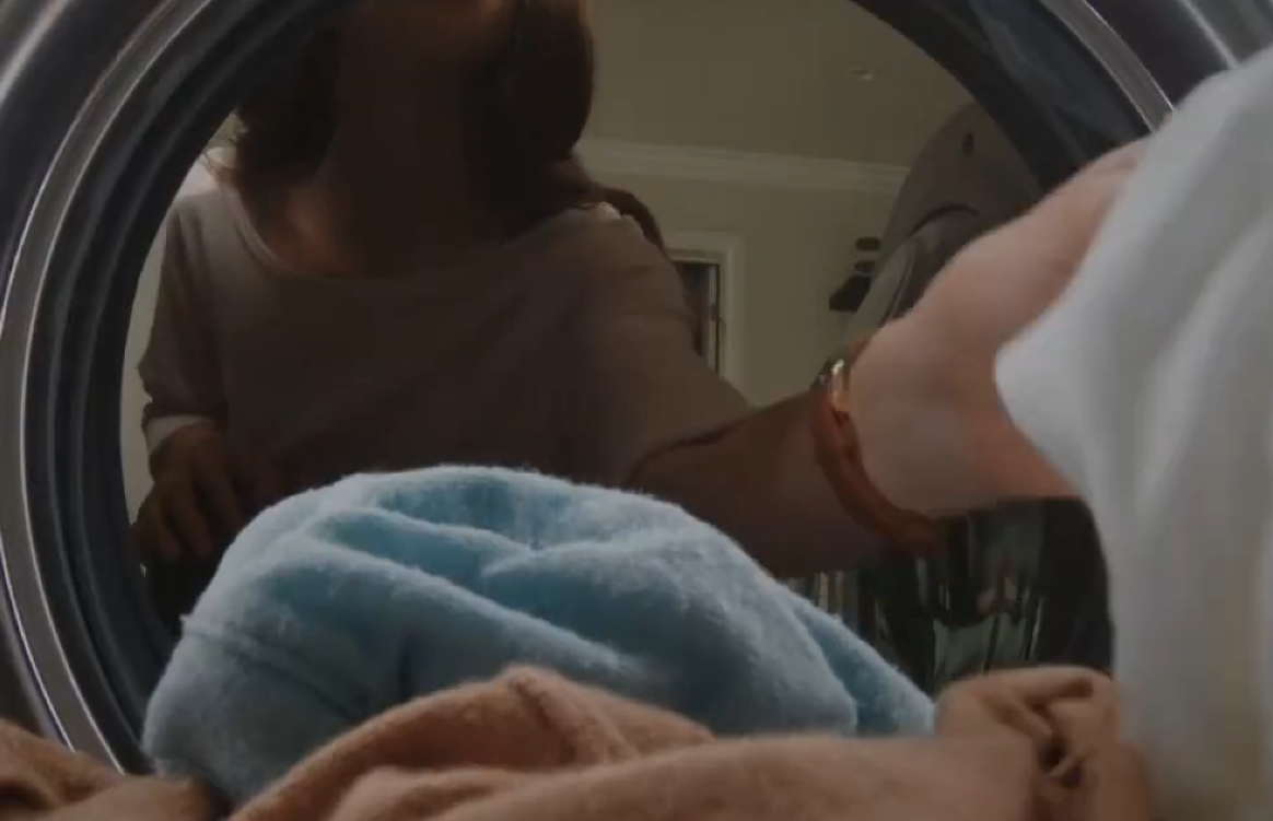 세탁기 앞에서 세탁물을 꺼내는 모습